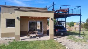 Casa con balcón, mesa y coche en Preciosa Casa con Terraza al Valle Grande, San Rafael Mendoza de 1 a 5 Personas, en Valle Grande
