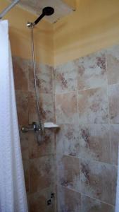 een douche met een douchekop in een badkamer bij Casa para 6 in Rocha