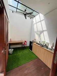 a room with a kitchen with a table and green grass at Sutji living in Sanur +20 photos
