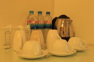 a group of white cups and teapots on a counter at Welnez World Residence Pattaya in Pattaya Central
