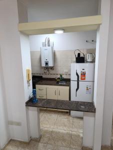 a small kitchen with a refrigerator and a sink at Dpto Centro de Carlos Paz - Avellana in Villa Carlos Paz