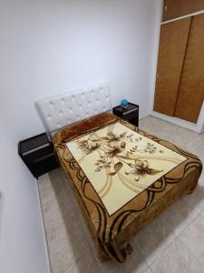 a bed in a room with a flower pattern on it at Dpto Centro de Carlos Paz - Avellana in Villa Carlos Paz