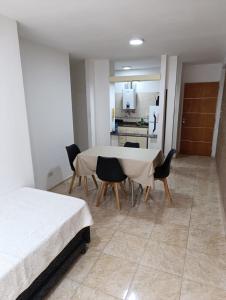 a room with a table and chairs and a kitchen at Dpto Centro de Carlos Paz - Avellana in Villa Carlos Paz