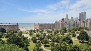 un parque con palmeras frente a una ciudad en El paraíso, en Mar del Plata