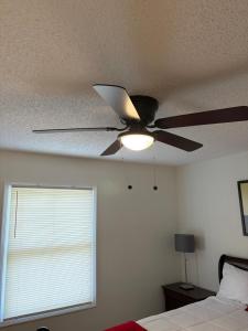 einen Deckenventilator in einem Schlafzimmer mit Fenster in der Unterkunft Home away from home in Atlanta
