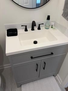 ein weißes Waschbecken mit einem Spiegel darüber in der Unterkunft Home away from home in Atlanta + 15 Fotos