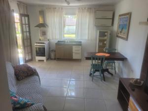a kitchen and living room with a table and chairs at Beach house in Pontal do Paraná