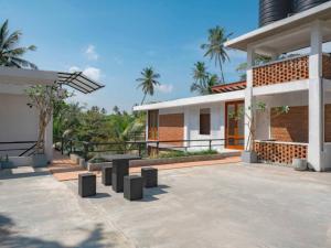 a house with a courtyard with a building at Ko Lake Villa in Ahangama