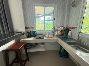 eine Küchentheke mit Spüle und Fenster in der Unterkunft Serene Jungle Stay House-Very Central- in Ko Phangan