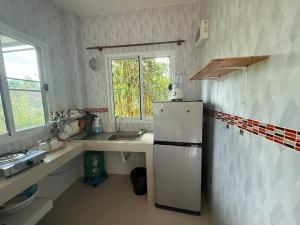 eine Küche mit einem weißen Kühlschrank und einer Spüle in der Unterkunft Serene Jungle Stay House-Very Central- in Ko Phangan