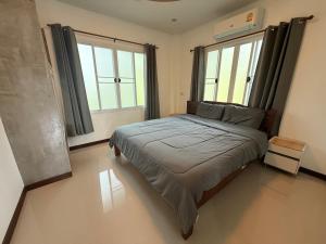 ein Schlafzimmer mit einem Bett und zwei Fenstern in der Unterkunft Serene Jungle Stay House-Very Central- in Ko Phangan