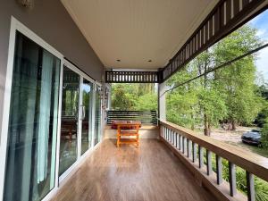eine Veranda mit einem Holztisch und einer Bank darauf in der Unterkunft Serene Jungle Stay House-Very Central- in Ko Phangan