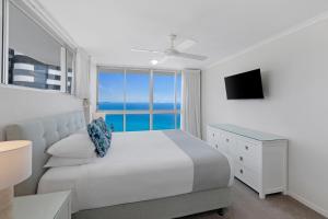 a white bedroom with a bed and a window at ULTIQA Points North in Gold Coast