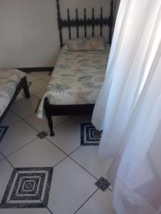 a bedroom with a bed and a tiled floor at Casa da alegria in Ubatuba +3 photos