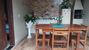 a kitchen with a wooden table with chairs and a refrigerator at Casa da alegria in Ubatuba