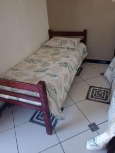 a small bed sitting on a tiled floor in a room at Casa da alegria in Ubatuba