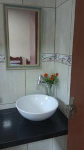 a white sink in a bathroom with a mirror at Casa da alegria in Ubatuba