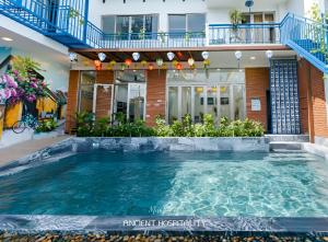 ein Swimmingpool vor einem Haus in der Unterkunft Ancient Beach Boutique & Spa - Beachfront Hotel in Hoi An