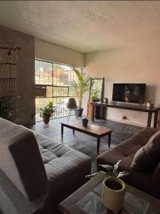 Hostal Casa Herrera في غواذالاخارا: غرفة معيشة بها أريكة وطاولة