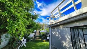 Encantadora Casa con Balcón a Pasos del Mar في لاس كروسيس: مبنى بسقف فوق ساحة +12 صورة