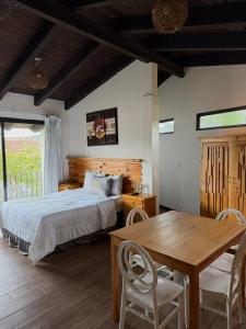 Departamentos San Francisco في سان كريستوبال دي لاس كازاس: غرفة نوم بسرير وطاولة وكراسي خشبية