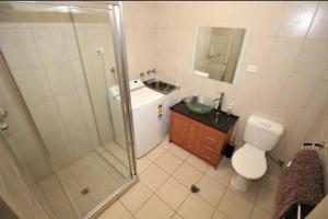 a bathroom with a shower and a toilet and a sink at Black Wattle Bungalow 30 Lake Bennett in Lake Bennett +8 photos