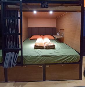 a bunk bed with two pillows on top of it at Autumn Living Hostel in Surabaya