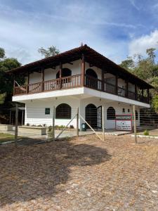 un edificio con un balcone in cima di Pousada Flat Royal Suíte com varanda e rede a Itapecerica