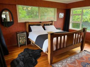 una camera da letto con un letto di legno in una stanza di Mount Taranaki Basecamp 4BR Farmhouse & Games Room 