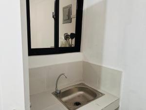 lavandino in una stanza con sopra uno specchio di 2BR Near Clark - Fast Wifi - Self Check-in a Mabalacat Altre 15 foto