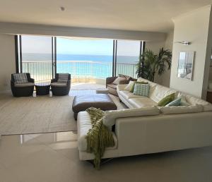 een woonkamer met een witte bank en uitzicht op de oceaan bij The Breakers in Gold Coast