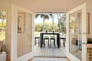 eine Glasschiebetür, die auf eine Terrasse mit einem Tisch führt in der Unterkunft OG14: 14 Ocean Green in Kiawah Island
