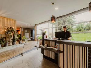 a man standing at a counter with a computer at Mercure Annecy Sud in Annecy +105 photos