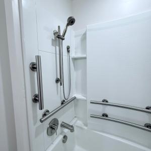 ein weißes Badezimmer mit einer Dusche mit Spiegel in der Unterkunft Modern Downtown SLC in Salt Lake City