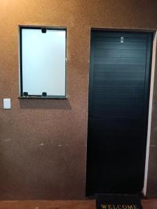 una porta nera in un edificio con finestra di Apto 06 - Canarinhos a Três Lagoas Altre 5 foto