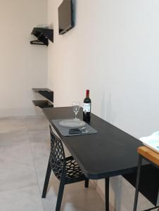 un tavolo nero con una bottiglia di vino e un bicchiere di Apto 06 - Canarinhos a Três Lagoas