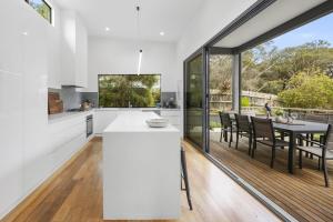 Bird House Wellness Retreat - Sauna Mineral Pool في راي: مطبخ بجدران بيضاء وطاولة مع كراسي