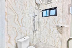 a bathroom with a shower with a toilet and a window at Grace House Syariah Cikarang RedPartner in Jatirarangan