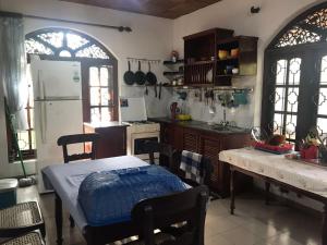 a kitchen with a table and a white refrigerator at Green Villa in Kahawa