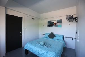 a bedroom with a blue bed with a cat on it at Funky Crab The River in Krabi
