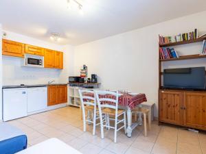 a kitchen with a table and chairs and a microwave at Appartement 6 pers. à Loudenvielle avec Wifi, proche Skyvall - FR-1-695-93 in Loudenvielle