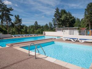 a swimming pool with lounge chairs in a resort at Chalet confortable avec terrasse et jardin - API-1-52-889 in La Chapelle