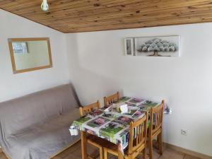 a dining room with a table and a couch at Chalet confortable avec terrasse - 4 personnes - API-1-52-908 in Saint-Rome-de-Tarn