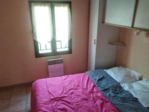 a bedroom with a bed with a pink blanket and a window at Chalet confortable avec terrasse - 4 personnes - API-1-52-908 in Saint-Rome-de-Tarn +16 photos