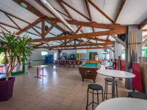 a large room with tables and a pool table at Chalet confortable avec terrasse - 4 personnes - API-1-52-908 in Saint-Rome-de-Tarn