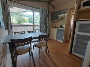 Una cocina y un comedor con mesa y sillas. en Chalet pour 2 avec Terrasse - Rampe d'accès - API-1-52-922, en Soubès 18 fotos más