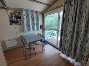 Un comedor con mesa y sillas y una ventana. en Chalet pour 2 avec Terrasse - Rampe d'accès - API-1-52-922, en Soubès