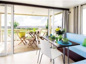 uma sala de estar com um sofá azul e uma mesa em Mobil home avec terrasse à Loudéac pour 4 personnes - API-1-52-898 em Loudéac