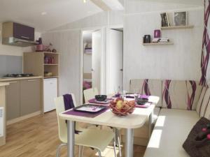 uma cozinha e sala de jantar com mesa e cadeiras em Mobil home avec terrasse à Loudéac pour 4 personnes - API-1-52-898 em Loudéac