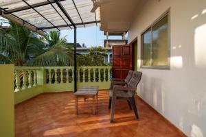 een balkon met een tafel en een stoel erop bij Ohana guest house in Calangute